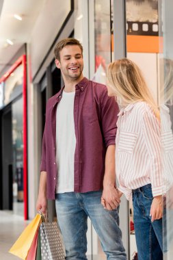 Alışveriş Merkezi deposundan çıkıp kağıt torbalar ile mutlu genç çift 