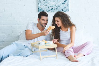 mutlu genç çift pijama yatak odasında birlikte kahvaltı