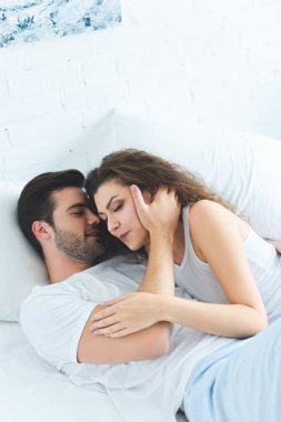 yüksek açı görüntülemek yan yana yatakta yatarken aşık güzel genç çiftin 