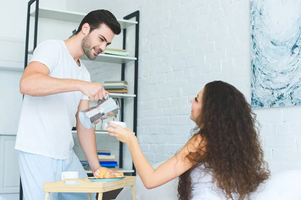 Bonito Sorrindo Jovem Derramando Café Para Bela Namorada Quarto — Fotos gratuitas