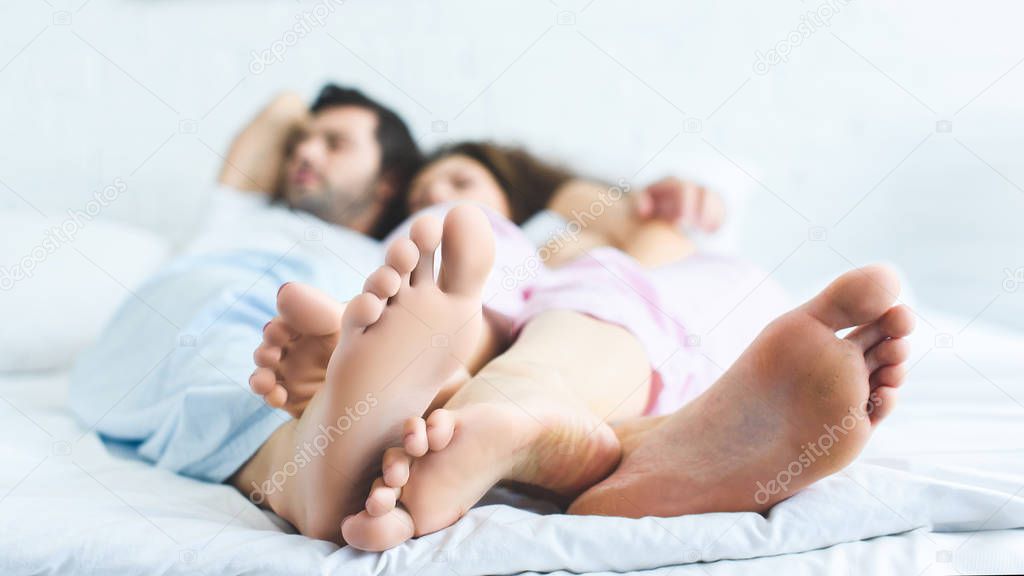 close-up view of feet of young couple sleeping together 