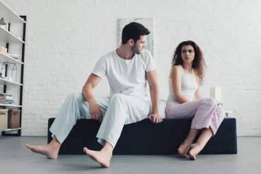 üzgün genç çift yatakta oturuyor ve birbirimizi, ilişki zorluklar kavramı pijama