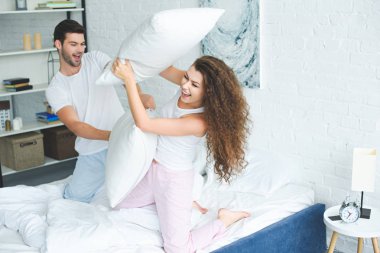 mutlu genç çift pijama yatak yastık ile mücadele 
