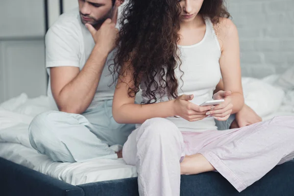 Cropped Shot Young Woman Using Smartphone While Upset Man Sitting — Stock Photo, Image
