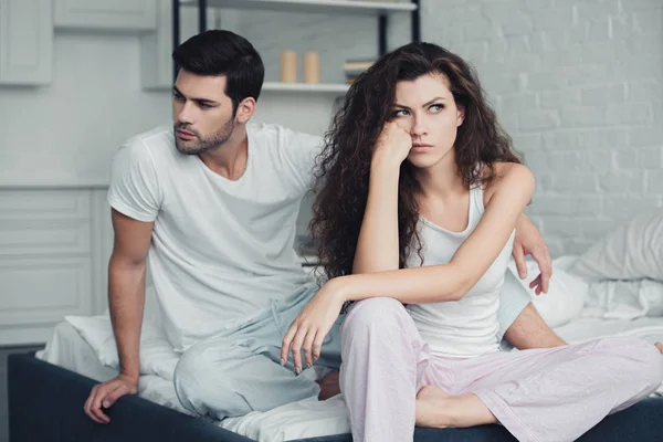 不满的年轻夫妇在睡衣有争吵床上 关系困难的概念 — 图库照片