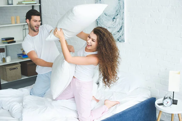 Feliz Jovem Casal Pijama Lutando Com Travesseiros Cama — Fotografia de Stock