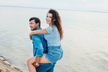 deniz kenarında plajda piggybacking gülümseyen güzel çift 