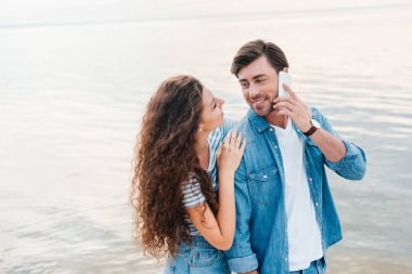 Erkek arkadaşı o Smartphone'da söz ederken sarılma kız  