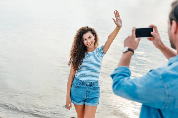 Man Tar Foto Attraktiva Viftande Flickvän Nära Havet Smartphone — Gratis stockfoto