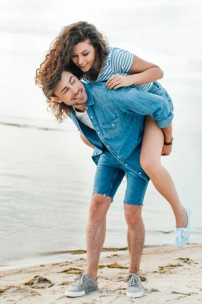 Happy Boyfriend Giving Piggyback His Girlfriend Seashore — Stock Photo, Image