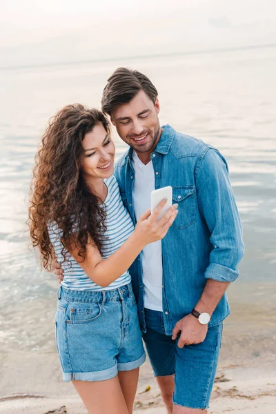 Jeune Couple Souriant Utilisant Smartphone Près Mer — Photo