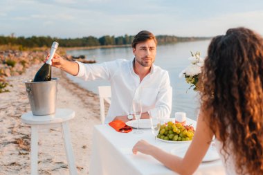 Erkek çekici şişe şampanya romantik tarih için deniz kıyısı