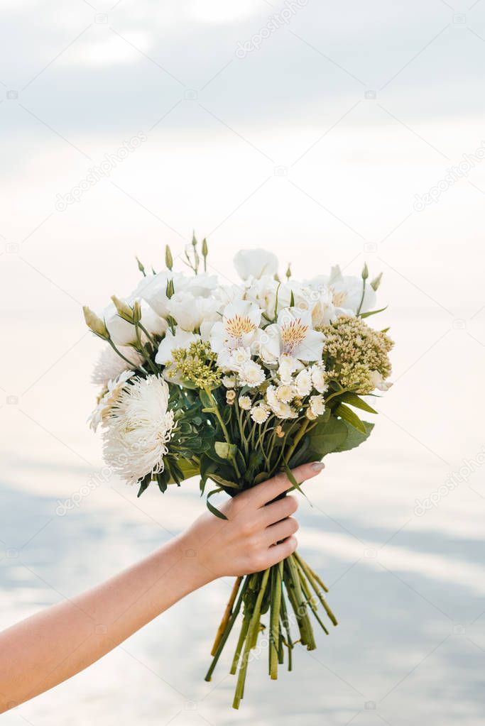 cropped view of woman holding beautiful bouquet with white flowers