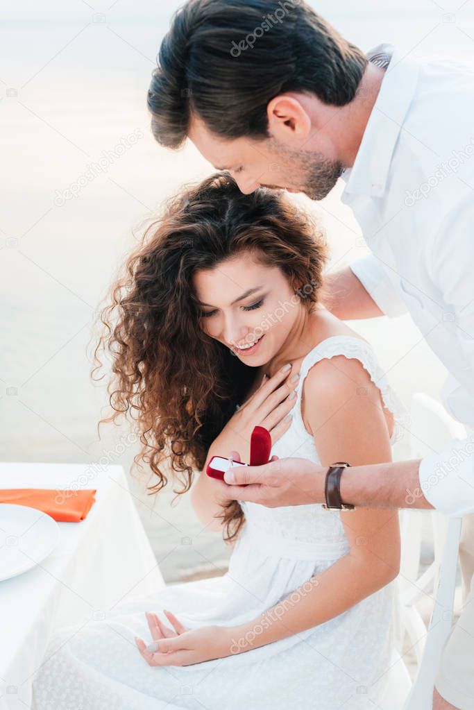 man making propose with ring to girlfriend in romantic date