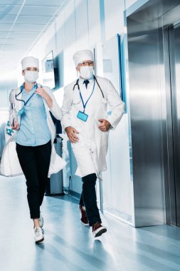 Erkek ve kadın doktorlar ile dijital tablet ve hastane koridorunda çalıştıran Pano 