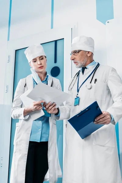 Low Angle View Mature Male Doctor Showing Paper Female Colleague — Stock Photo, Image