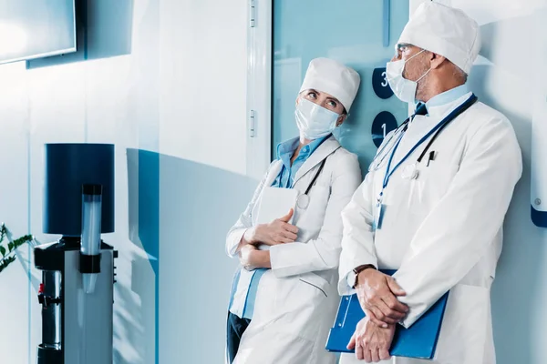 Male Female Doctors Medical Masks Standing Clipboard Digital Tablet Hospital — Stock Photo, Image