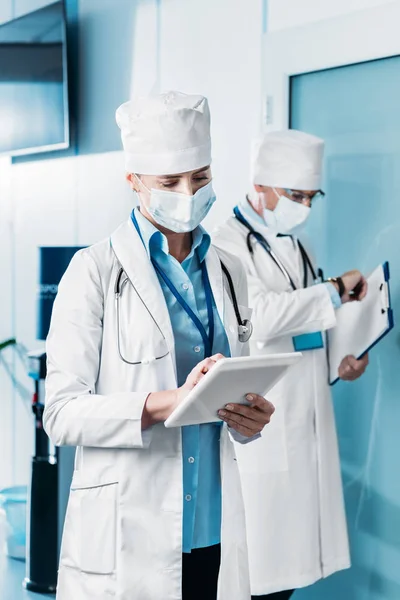 Female Doctor Medical Mask Using Digital Tablet While Her Male — Free Stock Photo