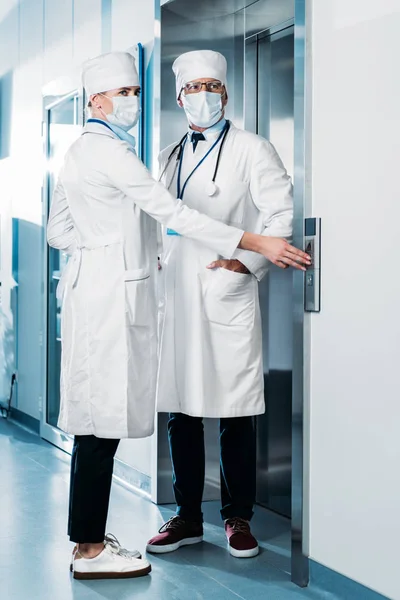 Male Female Doctors Medicals Masks Pushing Button Elevator Hospital Corridor — Stock Photo, Image