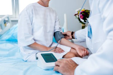 bir erkek doktor hastane odasında tonometer tarafından bayan hasta basınç ölçme resim kırpılmış