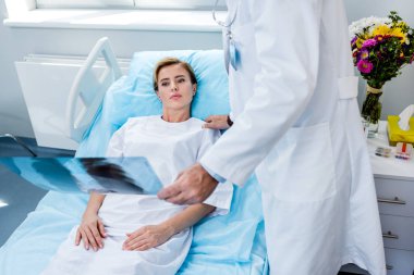 x-ışını resim holding ve hastane odasında Bayan hasta tezahürat erkek doktor görüntü kırpılmış