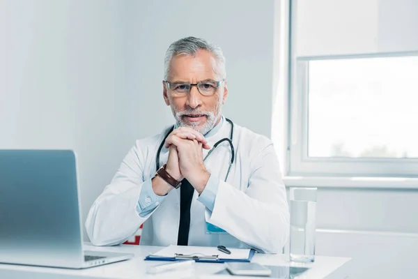 Smiling Middle Aged Male Doctor Looking Camera Table Laptop Office — Stock Photo, Image