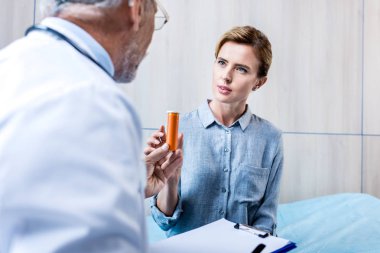 erkek doktor hastane odasında Bayan hasta için hapları vermeye Pano ile kısmi görünümünü 