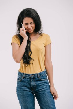 üzgün Afro-Amerikan kız ağlıyor ve yanında beyaz izole smartphone konuşuyor