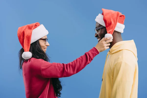 Side View African American Woman Adjusting Christmas Hat Boyfriend Head — Free Stock Photo