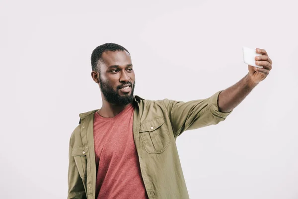 白で隔離のスマート フォン Selfie を取って笑顔のハンサムなアフリカ系アメリカ人  — 無料ストックフォト