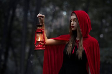 mistik kız gaz lambası ile karanlık ormanda yürüyüş