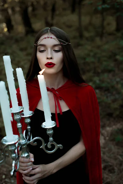 Beautiful Mystic Girl Red Cloak Wreath Blowing Candles — Free Stock Photo