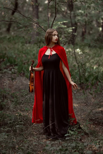 Menina Mística Elegante Vestido Preto Manto Vermelho Segurando Violino Madeiras — Fotografia de Stock