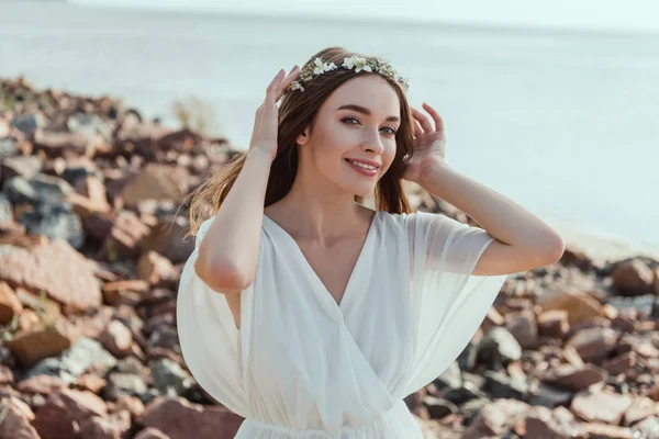 Gelukkig Meisje Poseren Witte Jurk Een Krans Rotsachtige Strand — Stockfoto