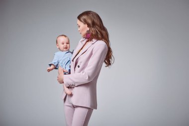 şık pembe Genç Anne yan görünüm uygun taşıma sevimli bebek kızı gri izole