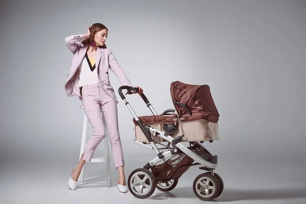 Beautiful Woman Stylish Suit Sitting Stool Looking Baby Carriage Grey — Stock Photo, Image