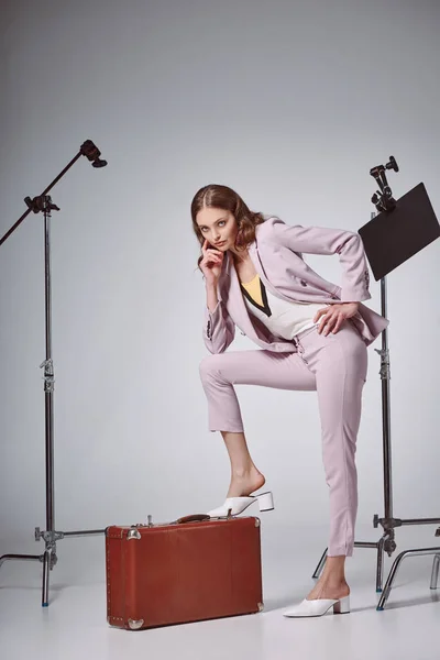 Beautiful Fashionable Woman Posing Suitcase Looking Camera Recording Studio — Free Stock Photo