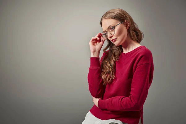 Κομψή Γυναίκα Προσαρμογή Γυαλιά Και Αναζητούν Μακριά Απομονωμένες Γκρι — Φωτογραφία Αρχείου