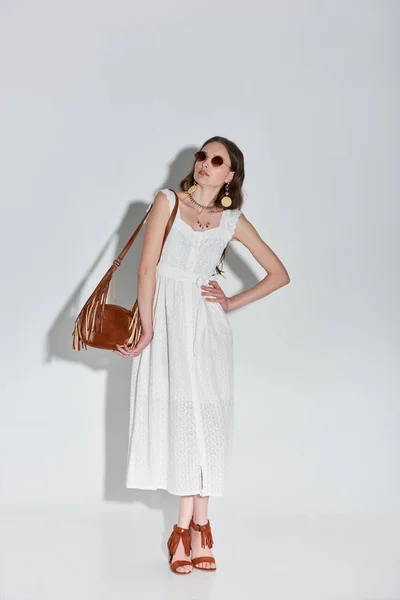 Красивая Стильная Женщина Модном Белом Платье Позирует Рукой Талии Сером — Бесплатное стоковое фото