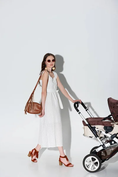 Stylowy Kobieta Białej Sukni Okulary Przeciwsłoneczne Chodzenie Wózek Patrząc Kamery — Zdjęcie stockowe