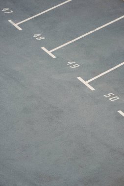 gri asfalt üzerinde sayılarla boş otoparklar