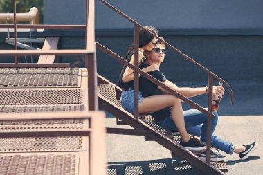 çok ırklı birkaç sarılma ve çatı merdivenlerde oturan viski şişesiyle