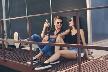 Asyalı kız arkadaşı ve beyaz erkek arkadaşıyla birlikte çatıda vakit ROM şişe
