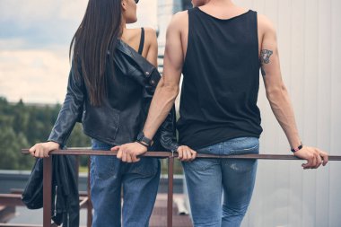 arkadan görünüşü genç şık çift ayakta parmaklıklar yakınındaki çatıda