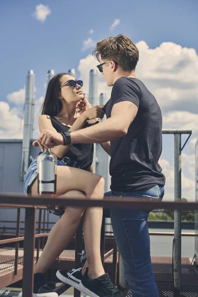 Beautiful Multicultural Couple Flirting Holding Bottle Whiskey Roof — Free Stock Photo