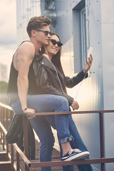 Pareja Multiétnica Escuchando Música Con Auriculares Tomando Selfie Teléfono Inteligente — Foto de stock gratis