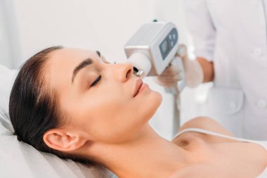 Elektrik masaj spa salonda güzellik uzmanı tarafından yapılan uyarıcı yüz almak güzel kadının kısmi görünümü