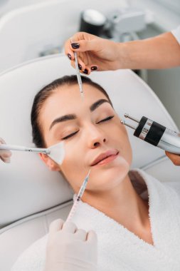 spa merkezi çeşitli yüz bakım donanımları kadınla