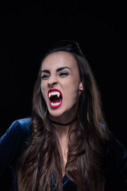 beautiful woman showing vampire teeth isolated on black clipart