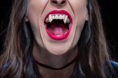 cropped view of woman showing vampire fangs isolated on black clipart